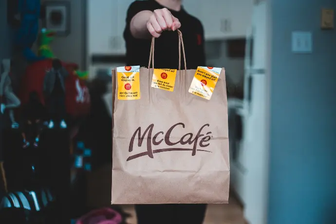 person holding white and brown paper bag